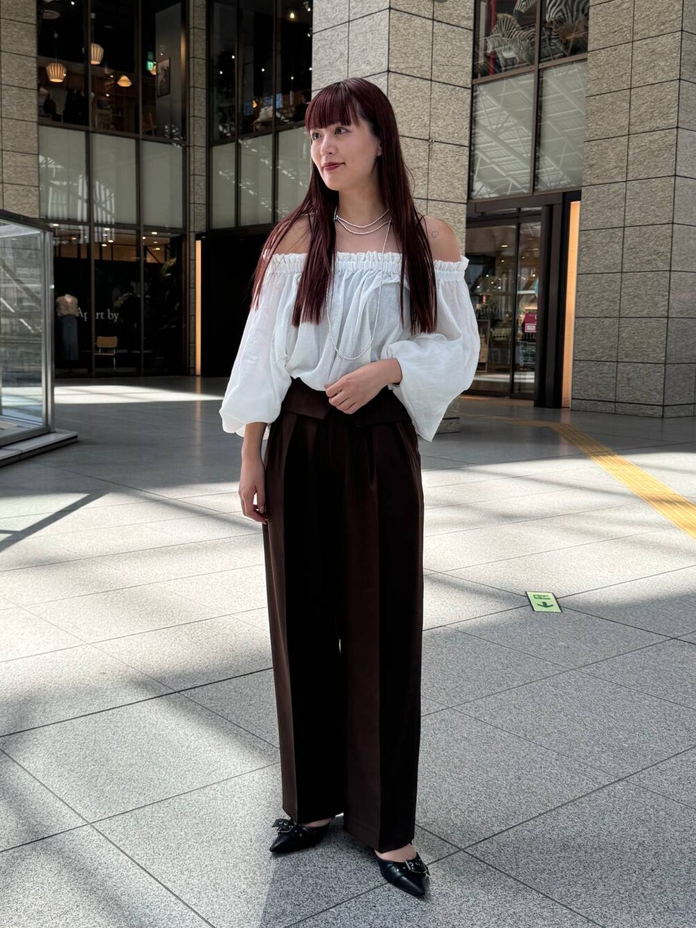 ホワイト系のシャツ/ブラウス、ブラウン系のスラックスを着用したレディースの秋コーディネートの2枚目の写真