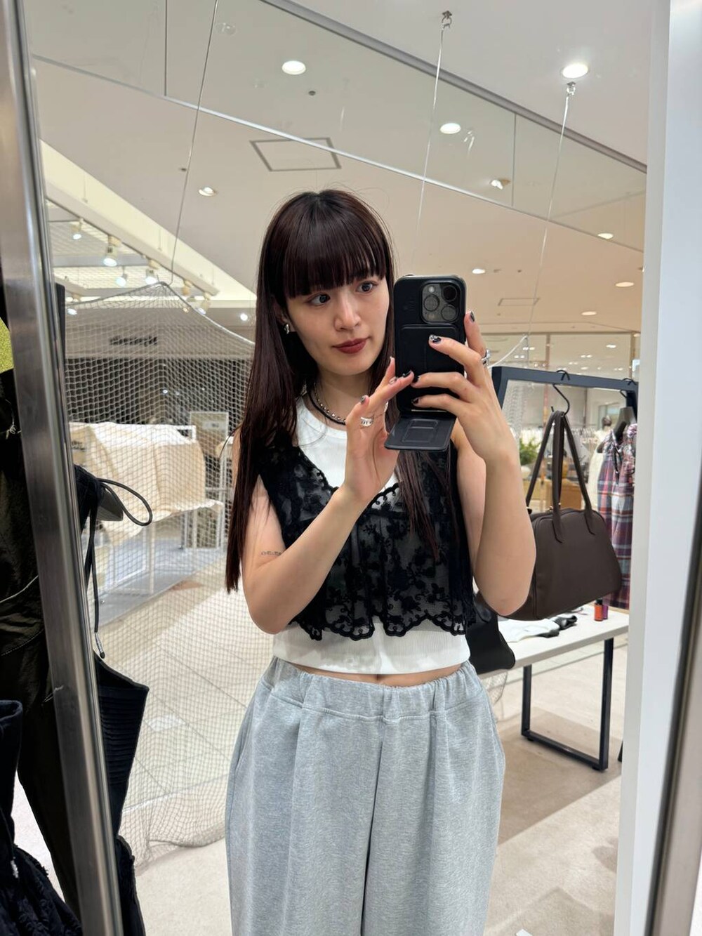 ホワイト系のタンクトップ、グレー系のスウェットパンツ、ブラック系のキャミソールを着用したレディースの夏コーディネートの2枚目の写真