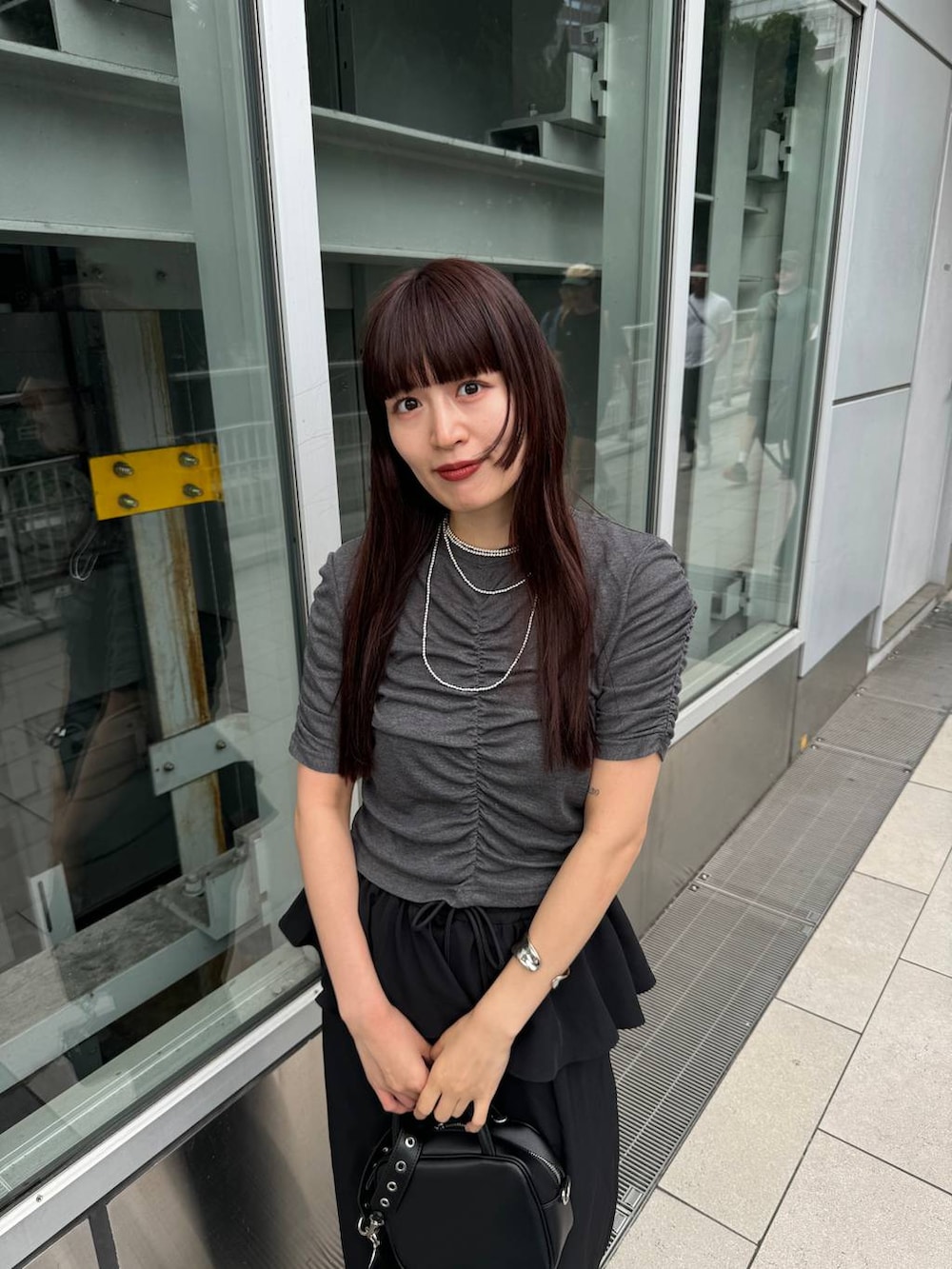 ブラック系のショルダーバッグ、グレー系のTシャツ/カットソー、ブラック系のその他パンツを着用したレディースの夏コーディネートの4枚目の写真