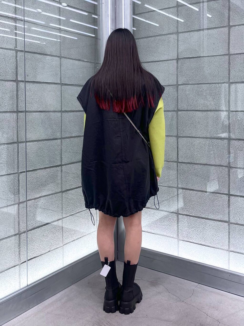 グリーン系のニット/セーター、ブラック系のショルダーバッグ、ブラック系のミリタリージャケットを着用したレディースの秋コーディネートの6枚目の写真