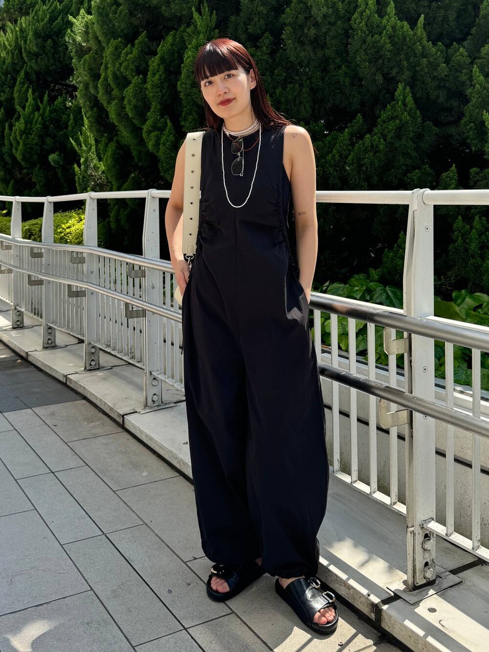 ホワイト系のショルダーバッグ、ブラック系のサロペット/オーバーオール、ブラック系のサンダルを着用したレディースの春コーディネートの7枚目の写真