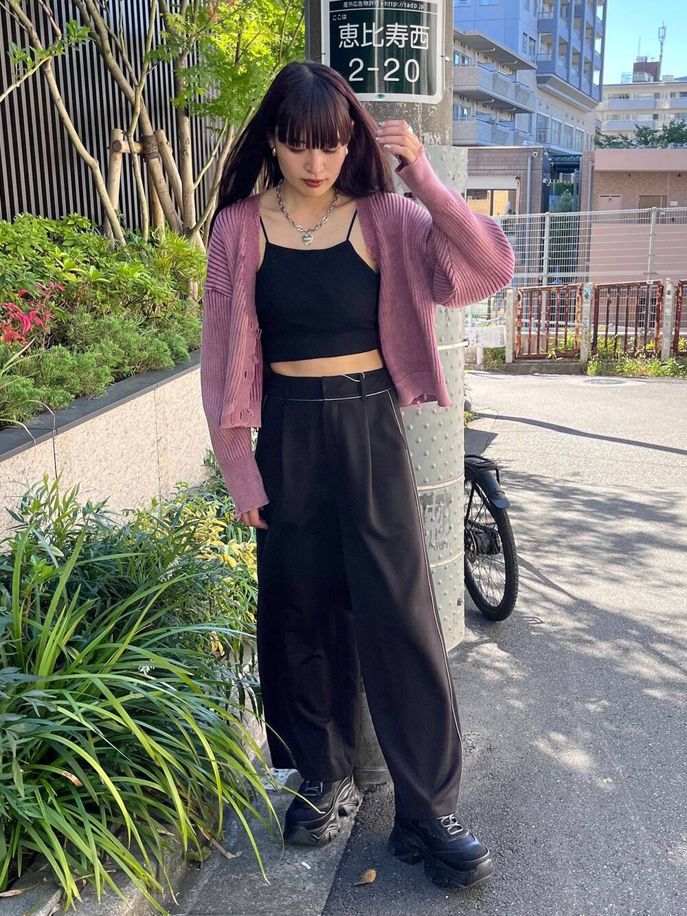 ブラック系のスニーカー、ブラック系のスラックス、ピンク系のカーディガン/ボレロを着用したレディースの秋コーディネートの5枚目の写真