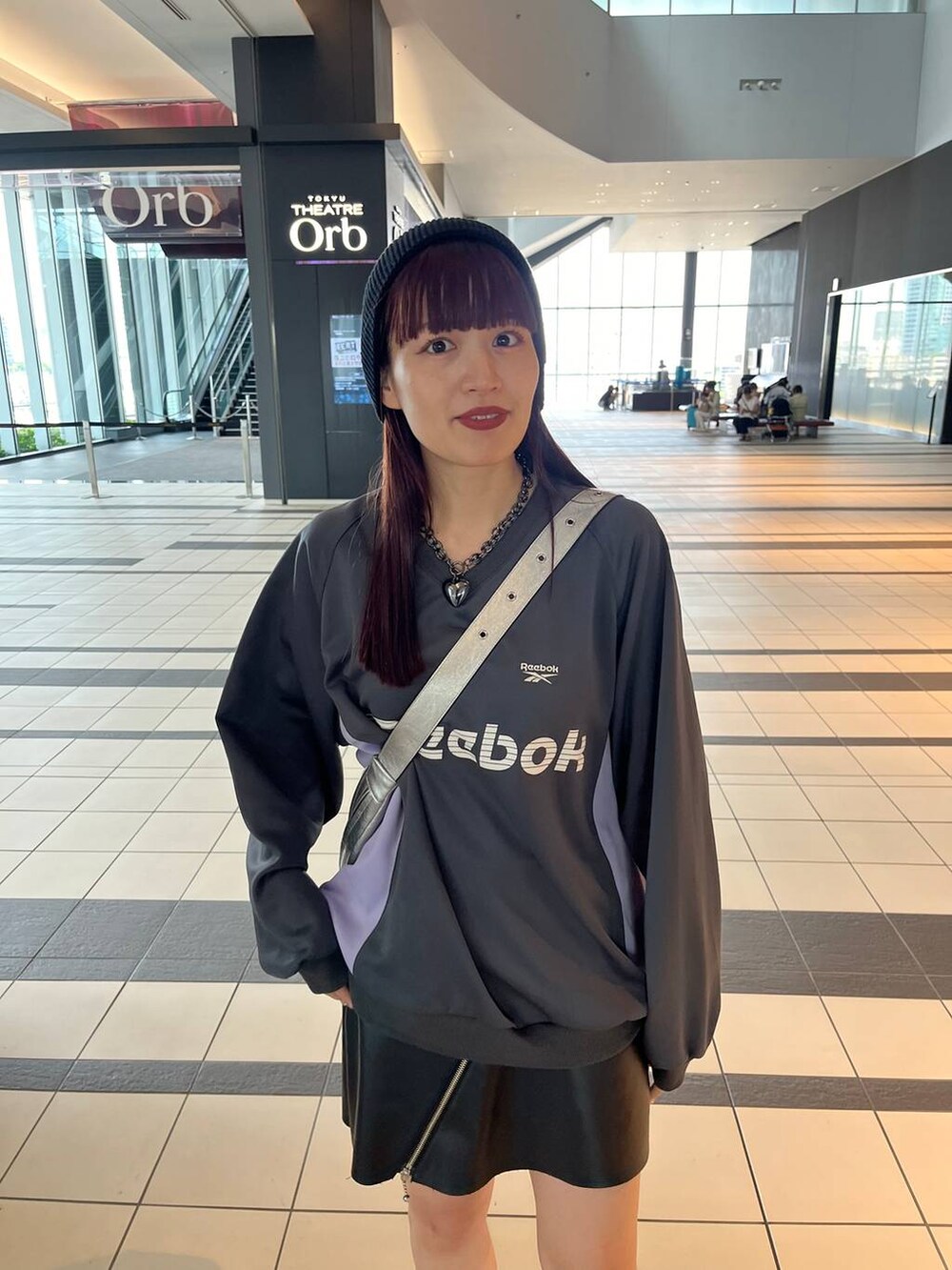 シルバー系のスニーカー、シルバー系のショルダーバッグ、グレー系のスウェットを着用したレディースの秋コーディネートの5枚目の写真