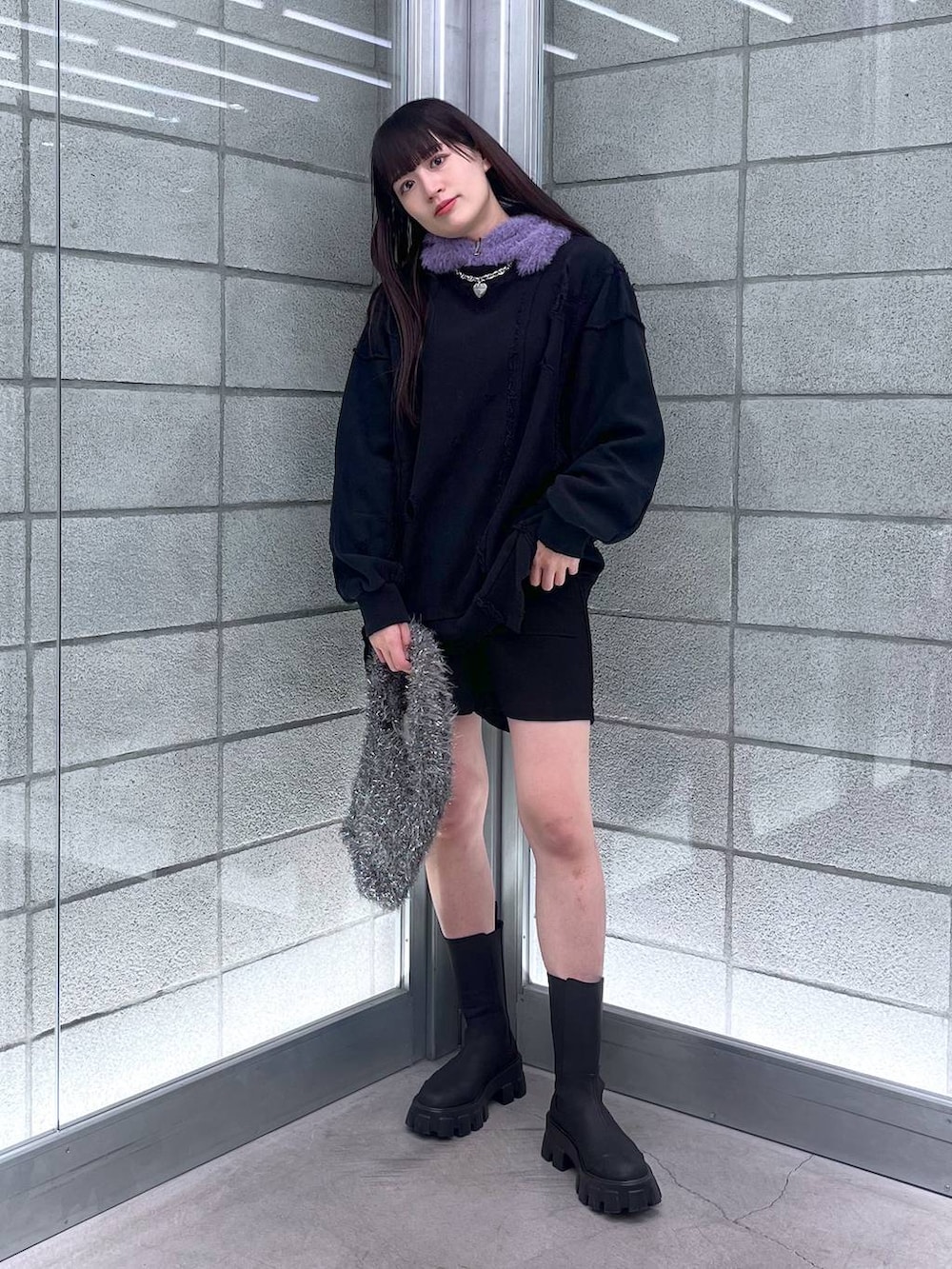 グレー系のハンドバッグ、ブラック系のスウェット、シルバー系のネックレスを着用したレディースの冬コーディネートの5枚目の写真