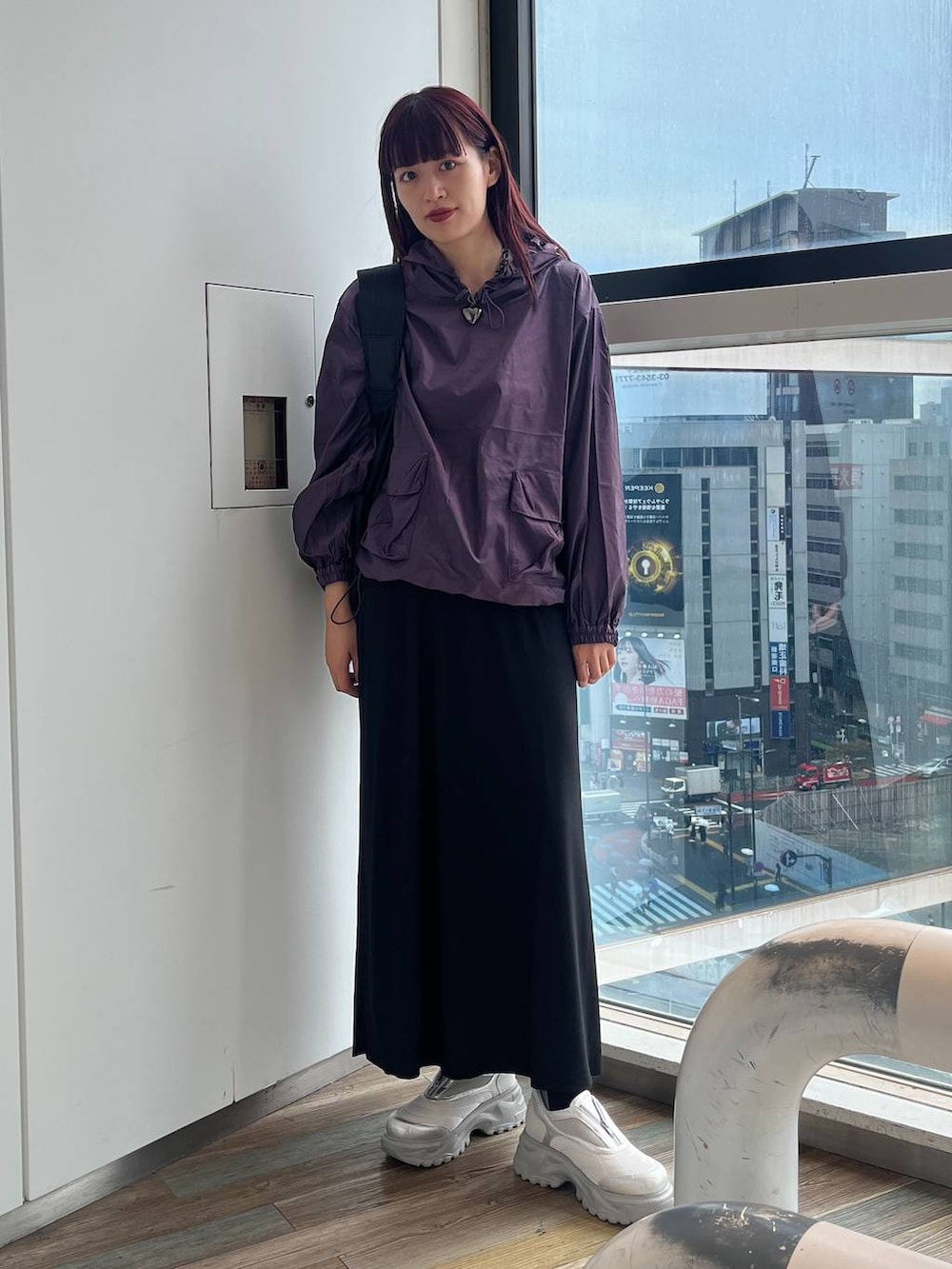 ブラック系のショルダーバッグ、ホワイト系のスニーカー、パープル系のパーカーを着用したレディースの秋コーディネートの2枚目の写真