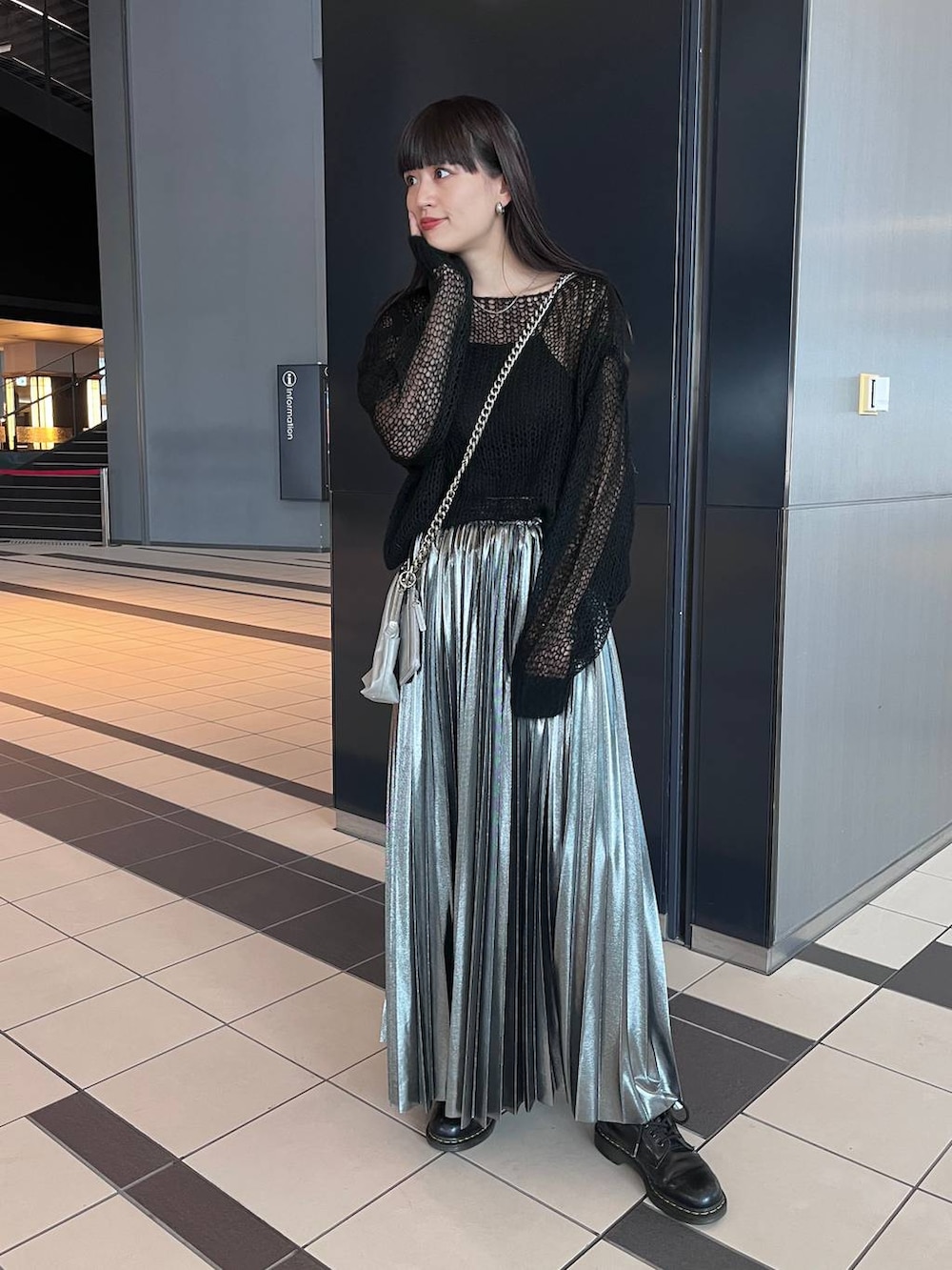 シルバー系のスカート、ブラック系のニット/セーターを着用したレディースの秋コーディネートの2枚目の写真