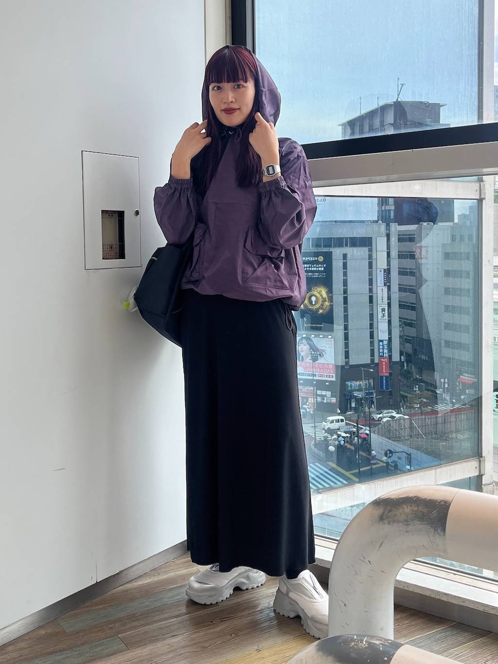 ブラック系のショルダーバッグ、ホワイト系のスニーカー、パープル系のパーカーを着用したレディースの秋コーディネートの5枚目の写真