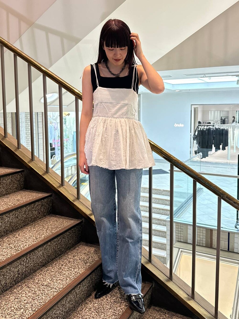 ホワイト系のキャミソール、ブルー系のデニムパンツを着用したレディースの春コーディネートの4枚目の写真