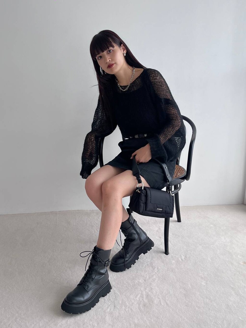 ブラック系のショルダーバッグ、ブラック系のブーツ、ブラック系のニット/セーターを着用したレディースの秋コーディネートの4枚目の写真