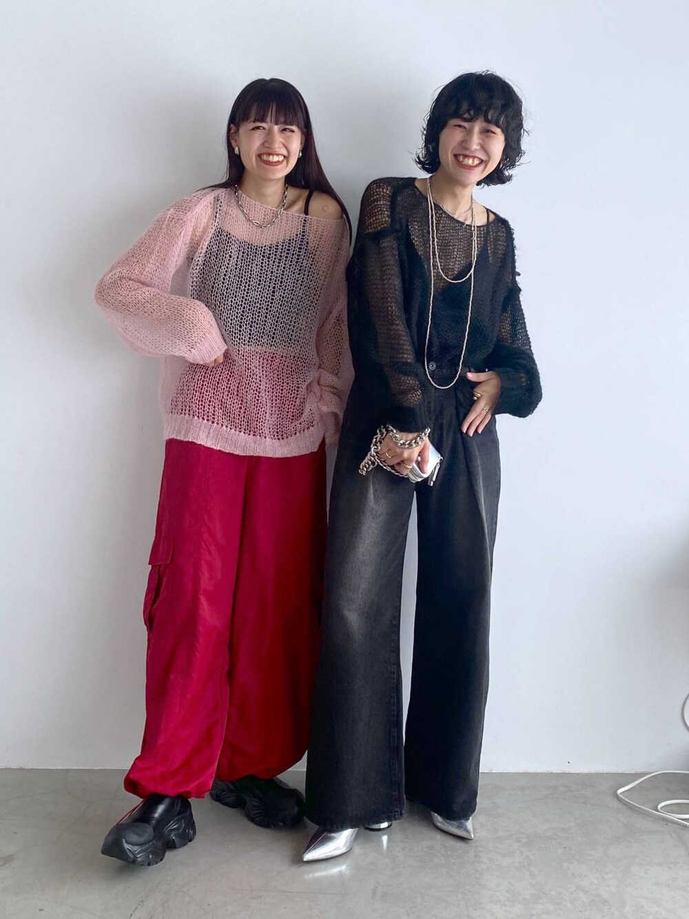 ブラック系のブーツ、シルバー系のショルダーバッグ、レッド系のカーゴパンツを着用したレディースの秋コーディネートの2枚目の写真