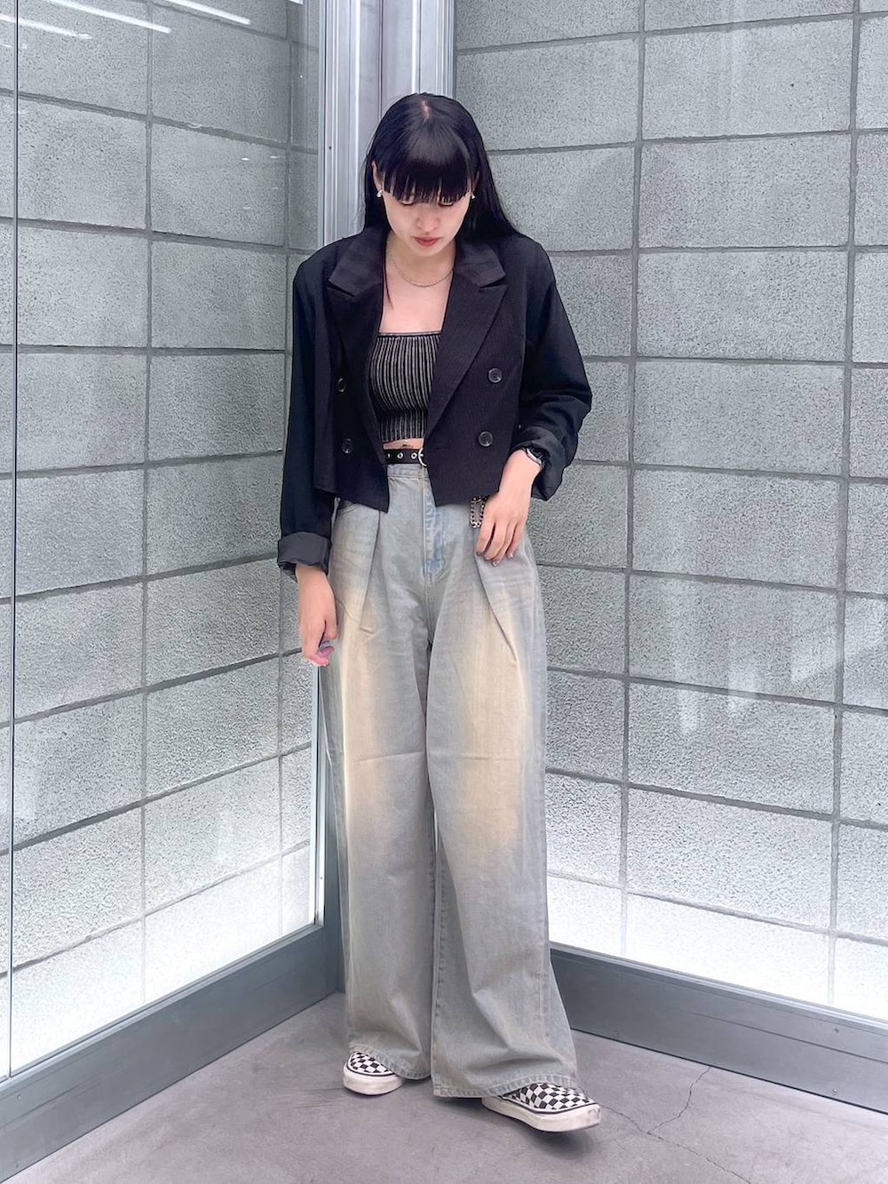 ブラック系のチューブトップ、ブルー系のデニムパンツ、ブラック系のテーラードジャケットを着用したレディースの夏コーディネートの3枚目の写真