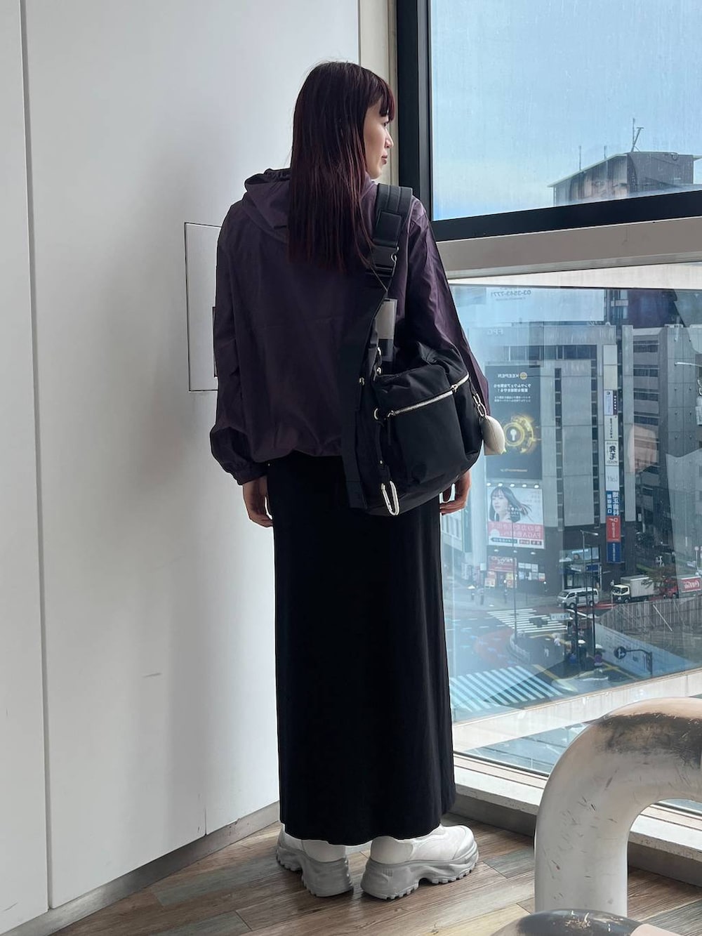 ブラック系のショルダーバッグ、ホワイト系のスニーカー、パープル系のパーカーを着用したレディースの秋コーディネートの4枚目の写真