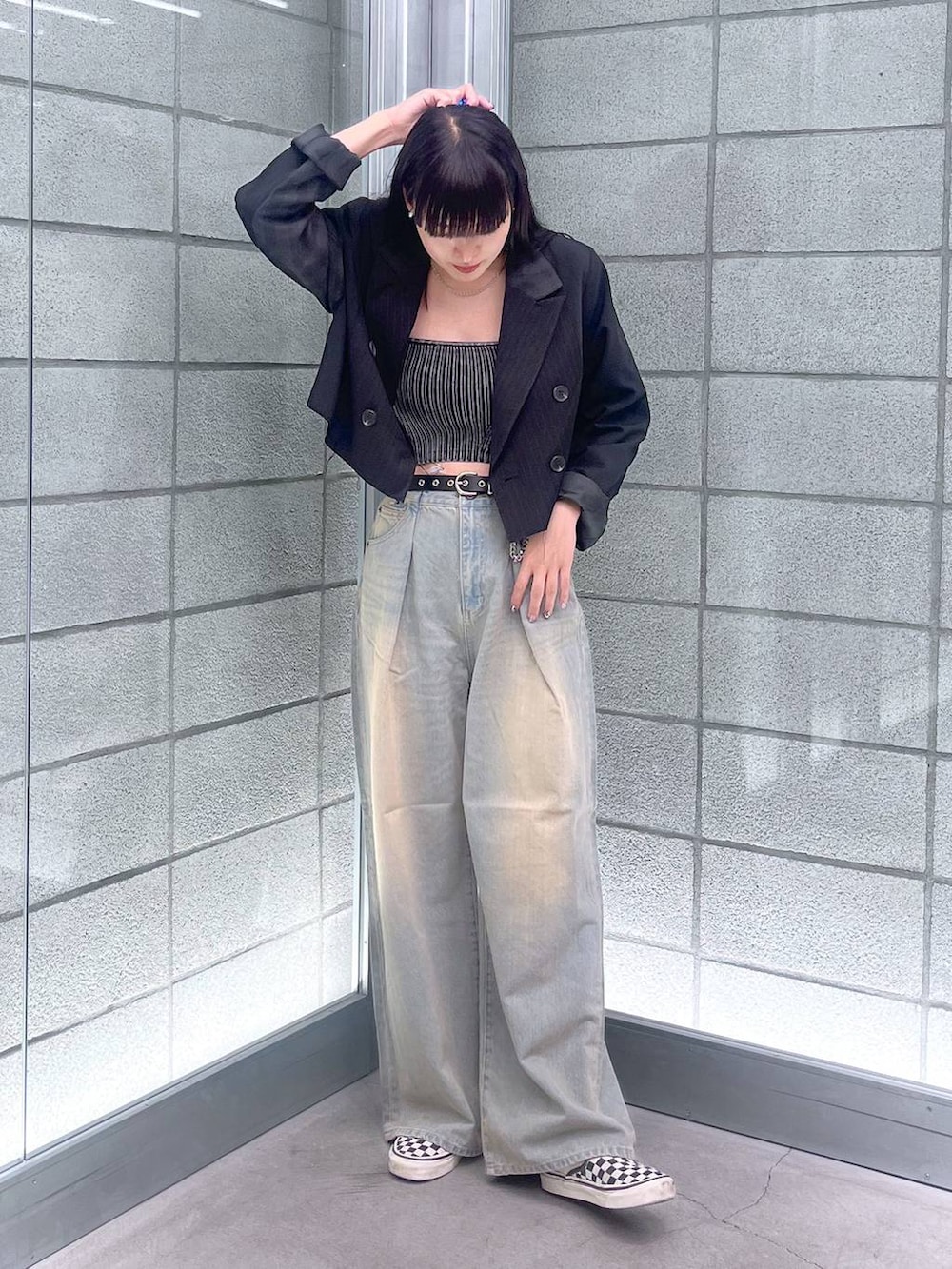 ブラック系のチューブトップ、ブルー系のデニムパンツ、ブラック系のテーラードジャケットを着用したレディースの夏コーディネートの4枚目の写真