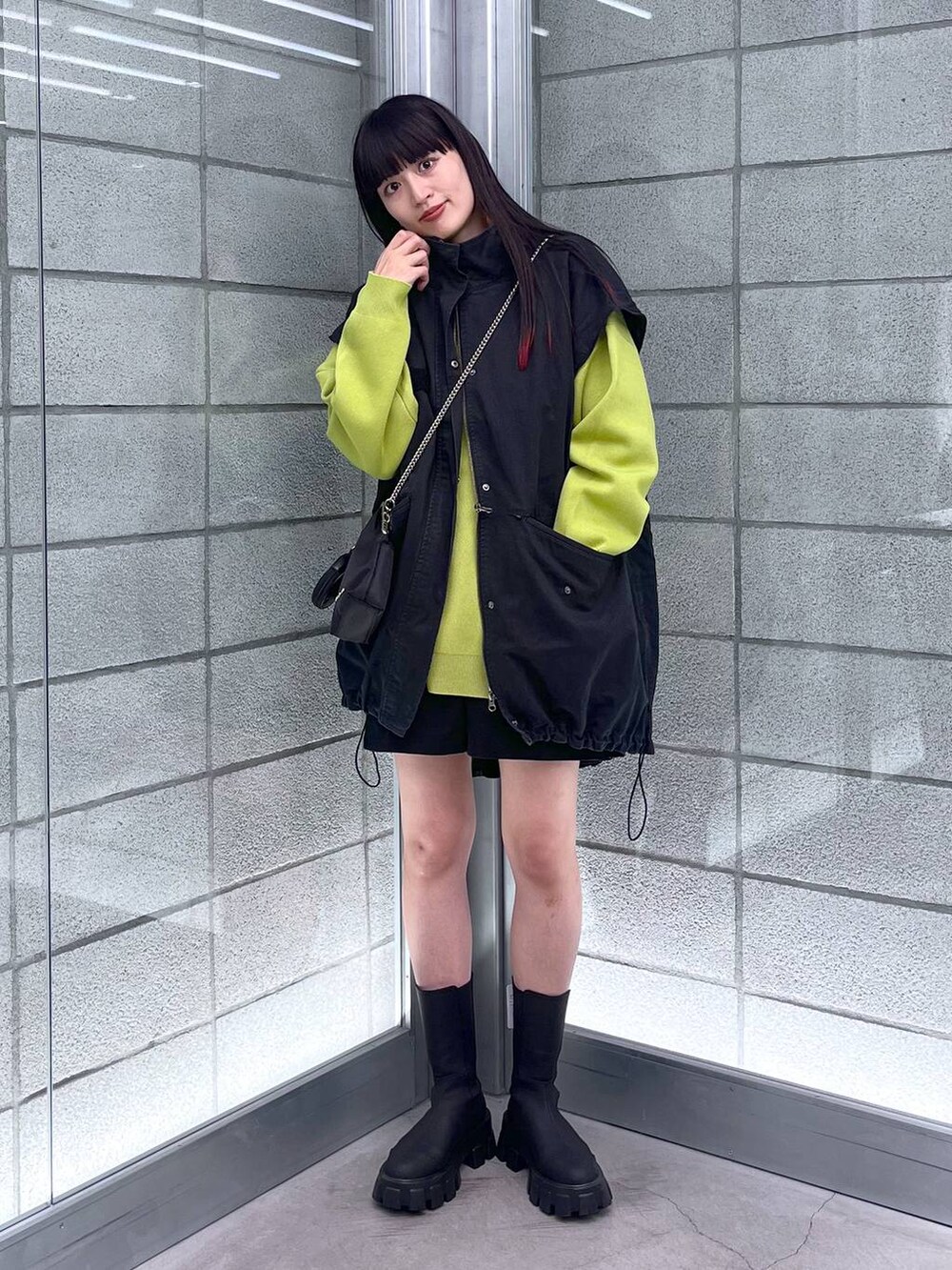 グリーン系のニット/セーター、ブラック系のショルダーバッグ、ブラック系のミリタリージャケットを着用したレディースの秋コーディネートの3枚目の写真