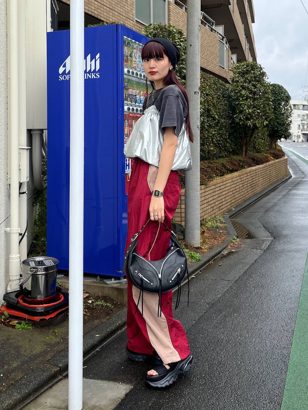 ブラック系のショルダーバッグ、レッド系のその他パンツ、ブラック系のTシャツ/カットソーを着用したレディースの冬コーディネートの5枚目の写真