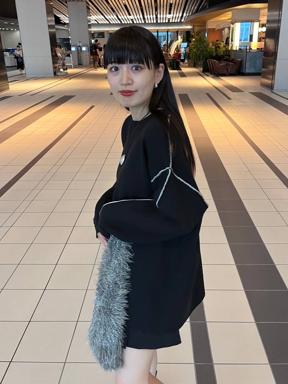 グレー系のハンドバッグ、ブラック系のニット/セーターを着用したレディースの秋コーディネートの8枚目の写真