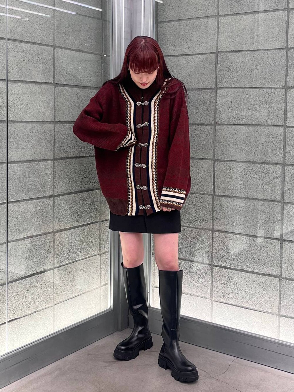 ブラウン系のカーディガン/ボレロ、ブラック系のスカート、ブラック系のブーツを着用したレディースの夏コーディネートの3枚目の写真