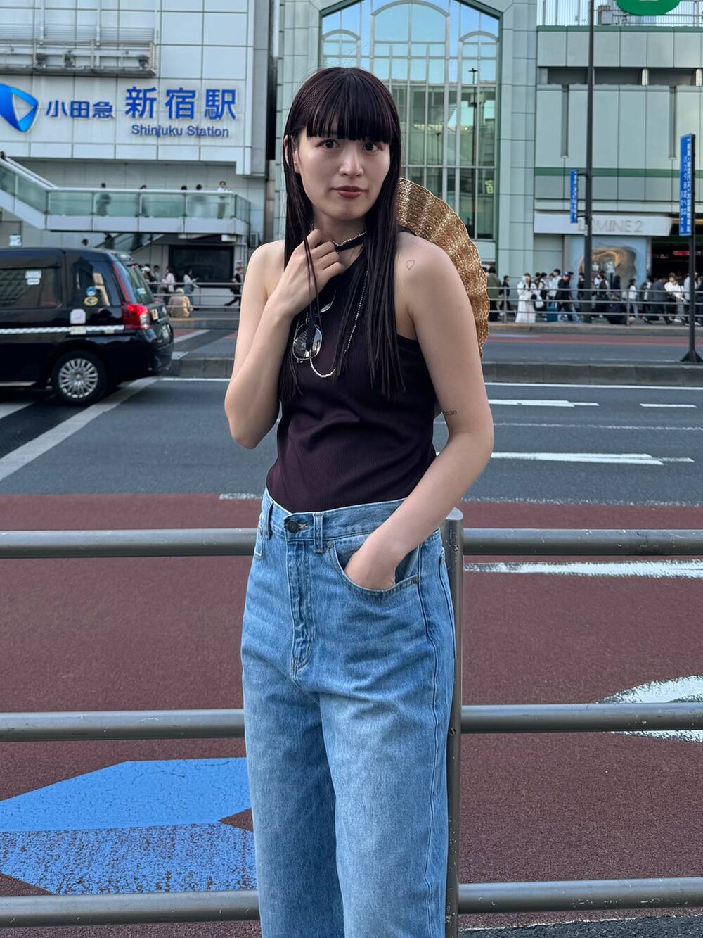 ブラック系のローファー、ブルー系のデニムパンツ、ブラウン系のタンクトップを着用したレディースの春コーディネートの4枚目の写真