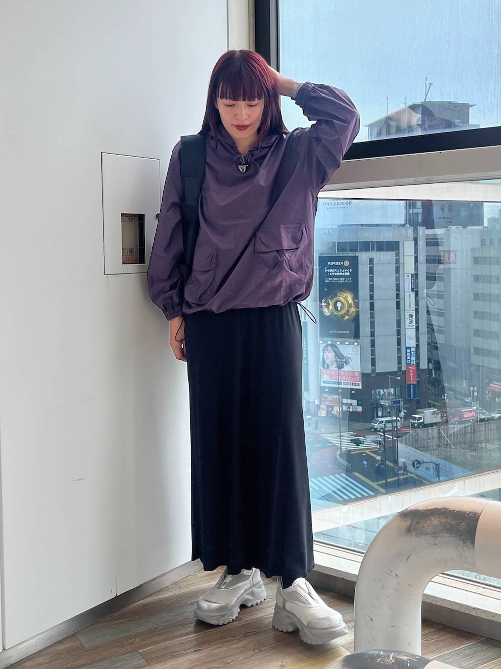 ブラック系のショルダーバッグ、ホワイト系のスニーカー、パープル系のパーカーを着用したレディースの秋コーディネートの6枚目の写真