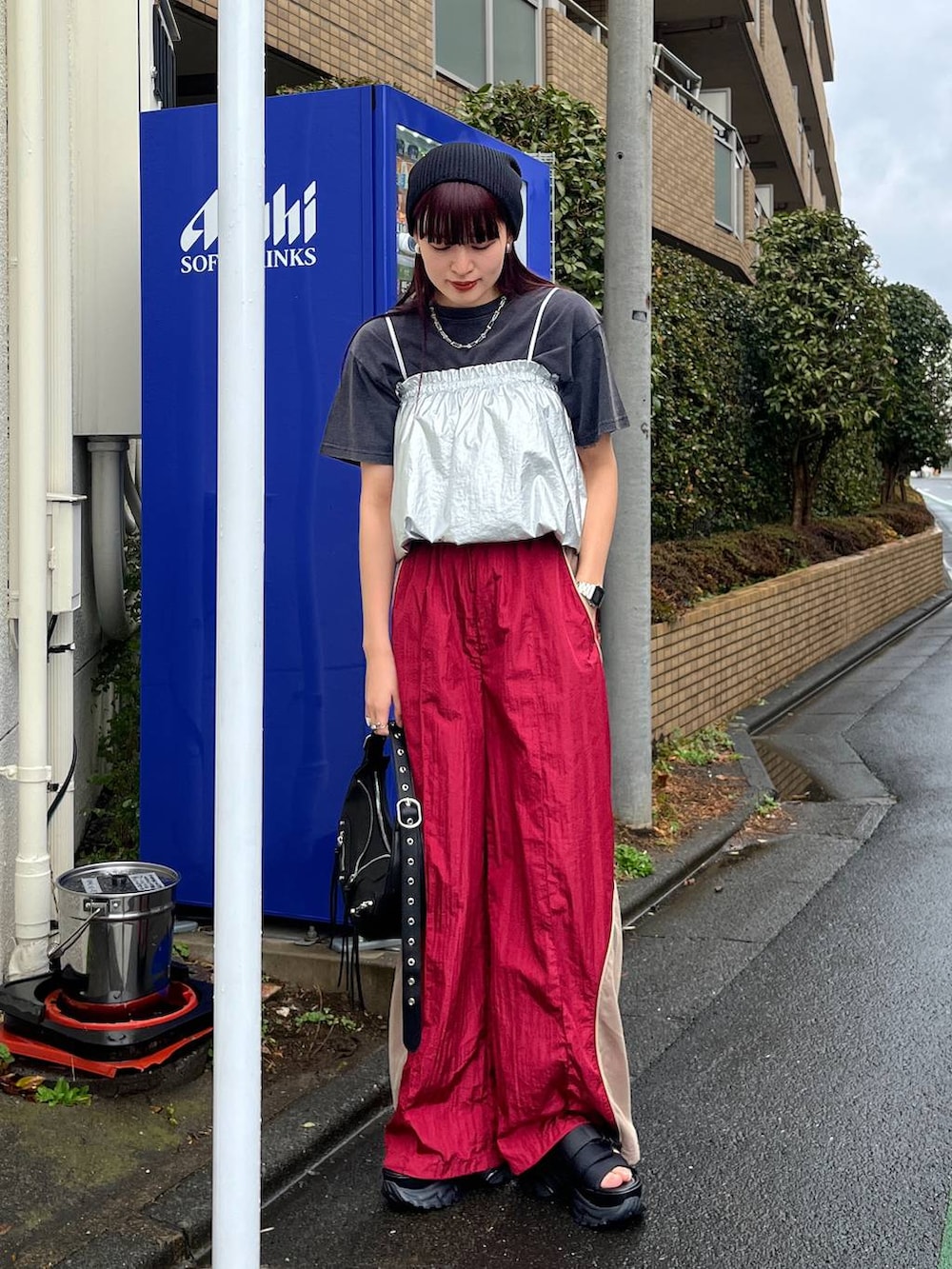 ブラック系のショルダーバッグ、レッド系のその他パンツ、ブラック系のTシャツ/カットソーを着用したレディースの冬コーディネートの2枚目の写真