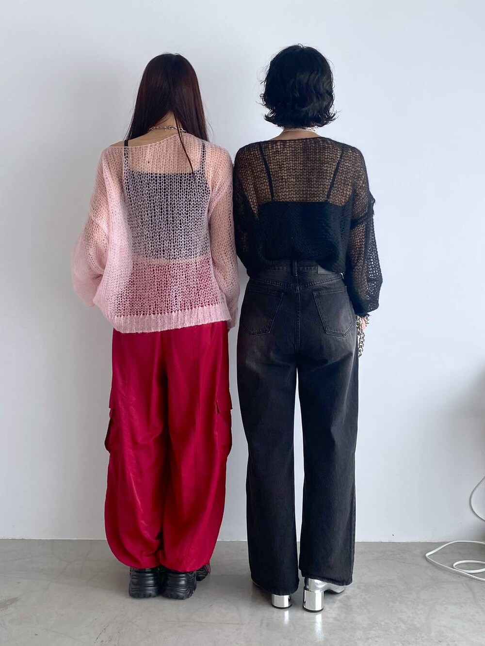 ブラック系のブーツ、シルバー系のショルダーバッグ、レッド系のカーゴパンツを着用したレディースの秋コーディネートの4枚目の写真