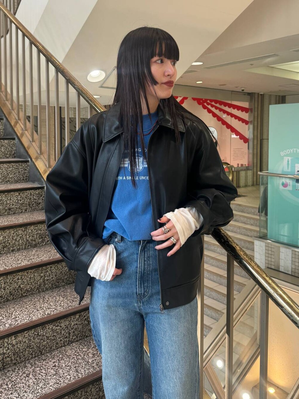 ブラック系のブルゾン、ブルー系のデニムパンツ、ブルー系のTシャツ/カットソーを着用したレディースの冬コーディネートの4枚目の写真