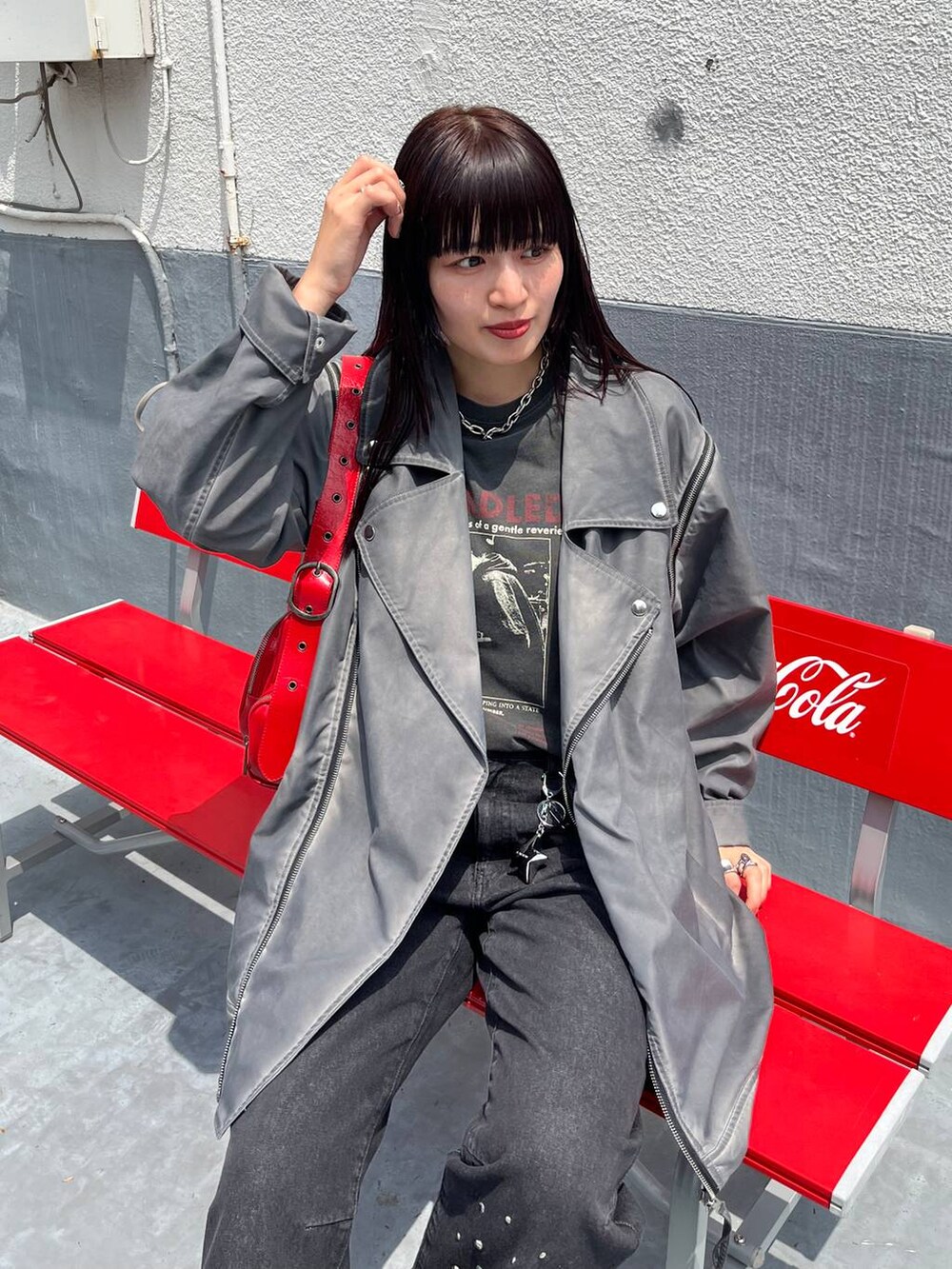 シルバー系のショルダーバッグ、ブラック系のTシャツ/カットソー、グレー系のライダースジャケットを着用したレディースの夏コーディネートの3枚目の写真