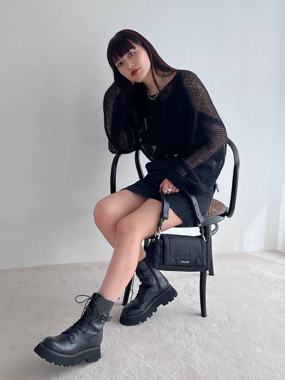 ブラック系のショルダーバッグ、ブラック系のブーツ、ブラック系のニット/セーターを着用したレディースの秋コーディネートの2枚目の写真