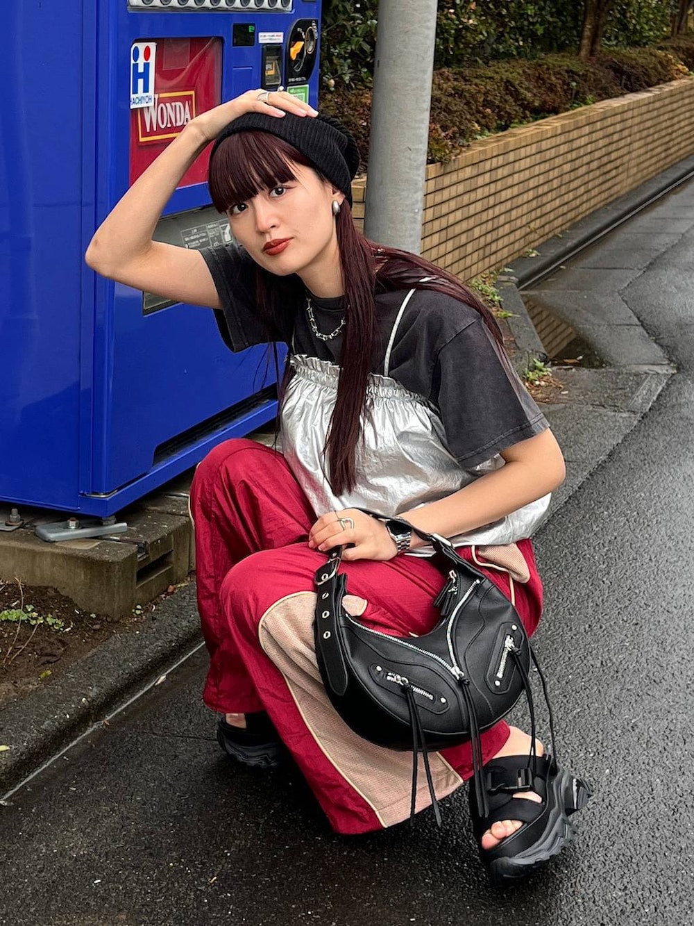 ブラック系のショルダーバッグ、レッド系のその他パンツ、ブラック系のTシャツ/カットソーを着用したレディースの冬コーディネートの4枚目の写真