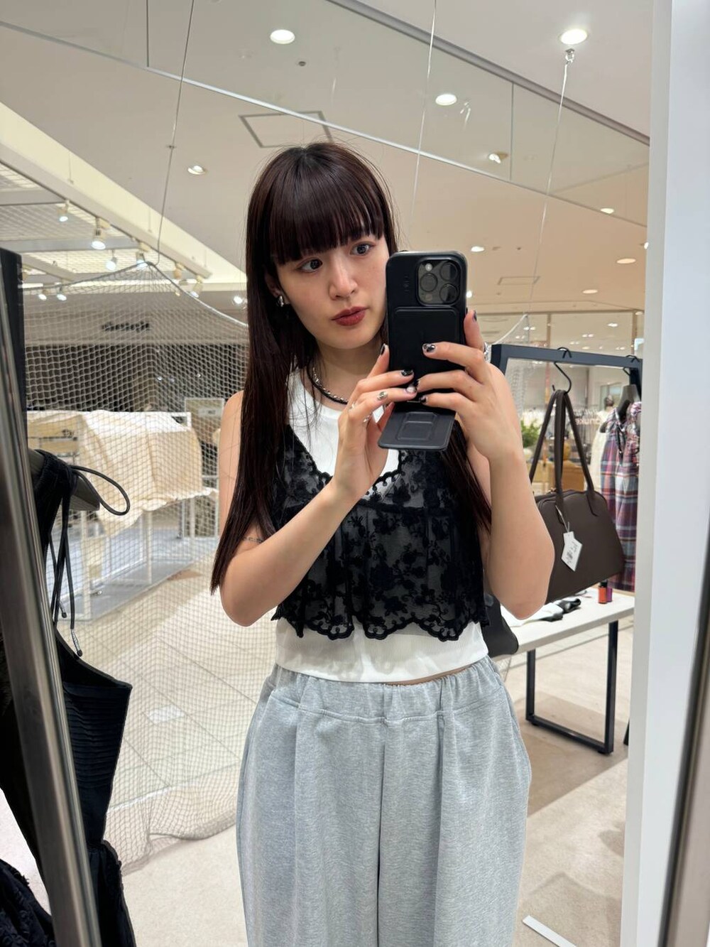 ホワイト系のタンクトップ、グレー系のスウェットパンツ、ブラック系のキャミソールを着用したレディースの夏コーディネートの4枚目の写真