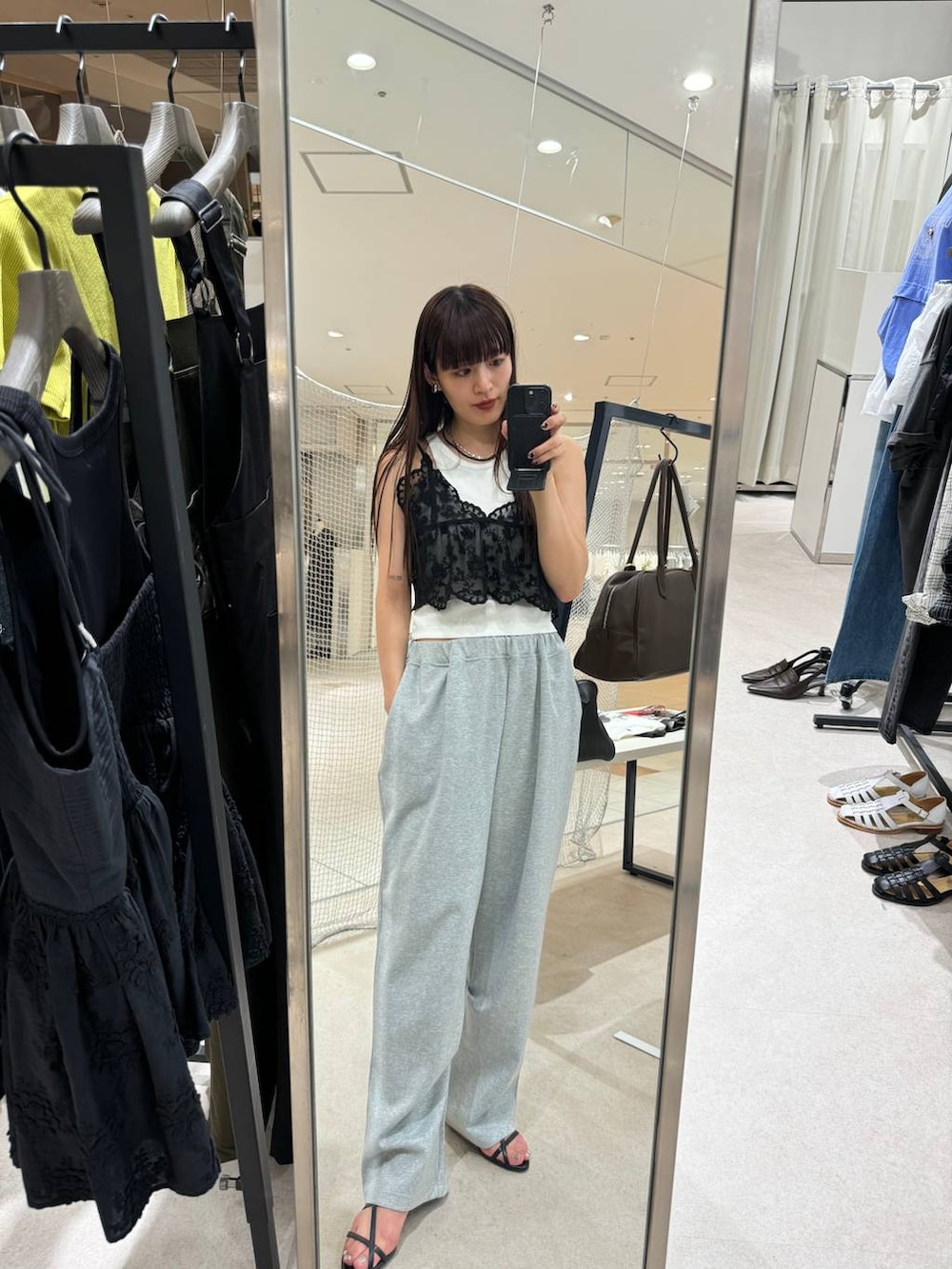 ホワイト系のタンクトップ、グレー系のスウェットパンツ、ブラック系のキャミソールを着用したレディースの夏コーディネートの3枚目の写真