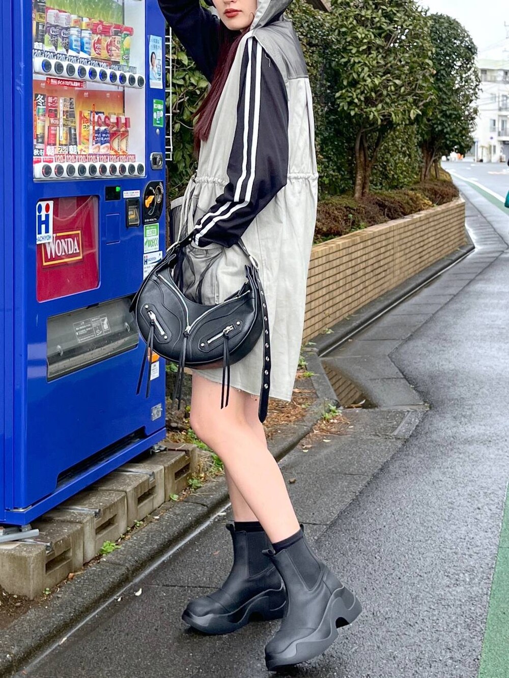 ブラック系のショルダーバッグ、ブラック系のTシャツ/カットソー、ブラック系のブーツを着用したレディースの冬コーディネートの5枚目の写真
