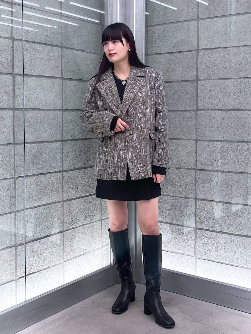 グレー系のテーラードジャケット、ブラック系のその他パンツを着用したレディースの秋コーディネートの2枚目の写真