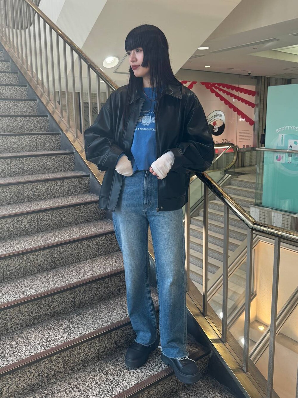 ブラック系のブルゾン、ブルー系のデニムパンツ、ブルー系のTシャツ/カットソーを着用したレディースの冬コーディネートの2枚目の写真