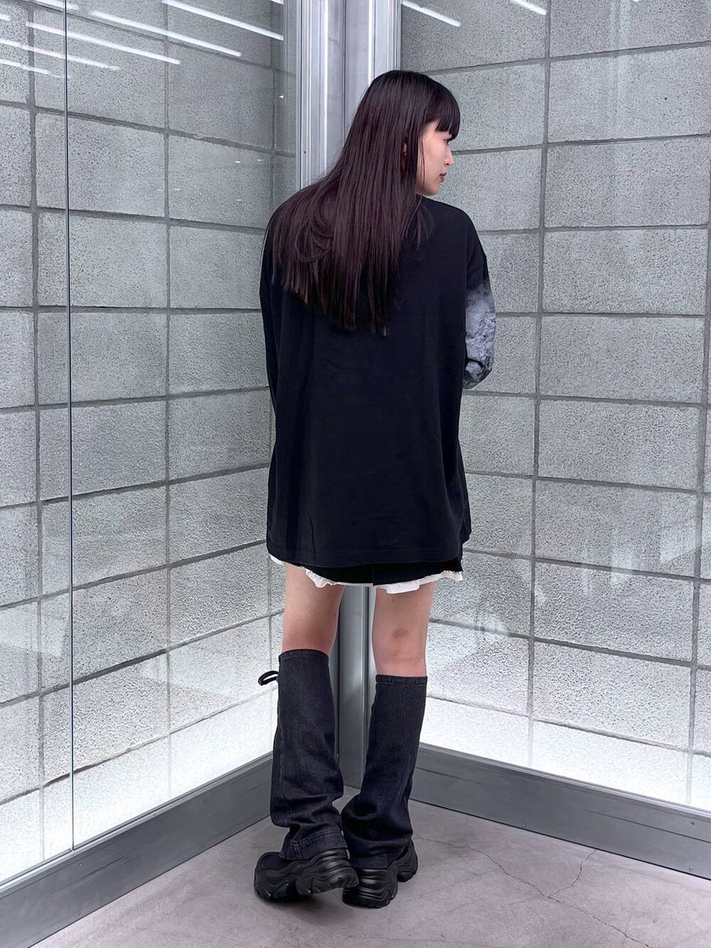 ブラック系のブーツ、ブラック系のスカート、ブラック系のTシャツ/カットソーを着用したレディースの夏コーディネートの6枚目の写真