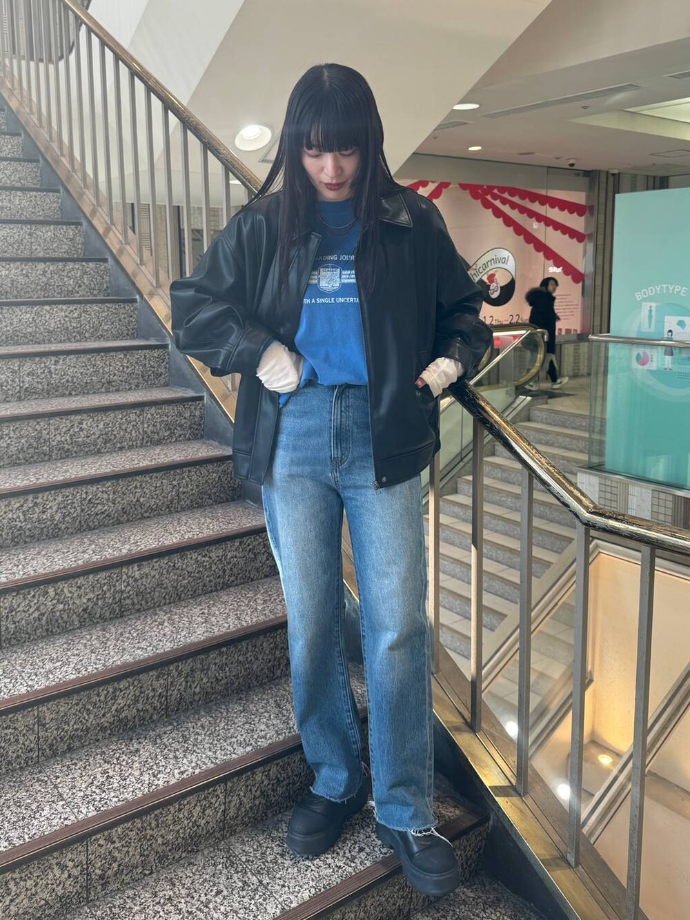 ブラック系のブルゾン、ブルー系のデニムパンツ、ブルー系のTシャツ/カットソーを着用したレディースの冬コーディネートの3枚目の写真