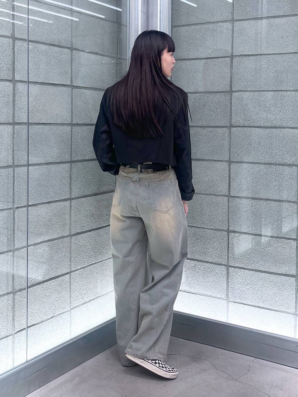 ブラック系のチューブトップ、ブルー系のデニムパンツ、ブラック系のテーラードジャケットを着用したレディースの夏コーディネートの5枚目の写真