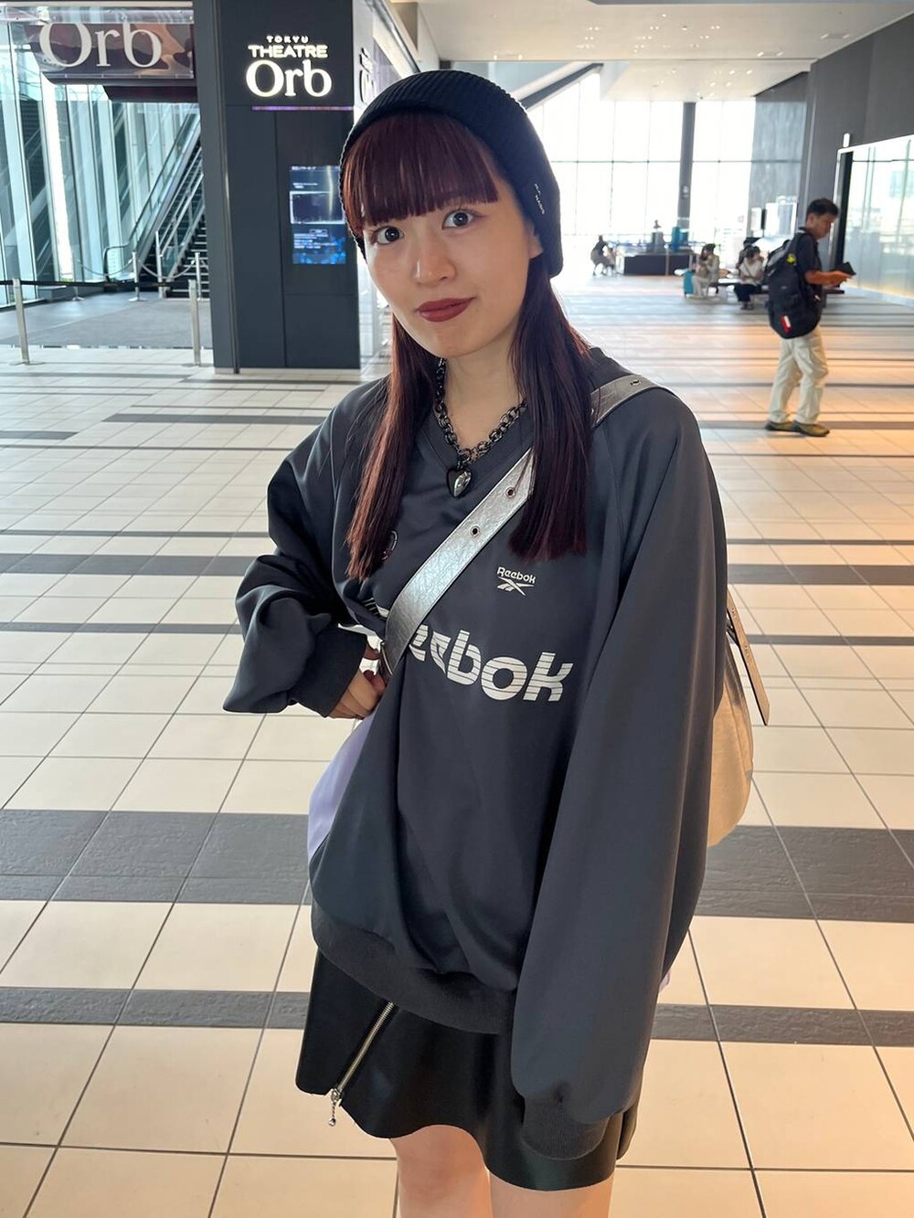 シルバー系のスニーカー、シルバー系のショルダーバッグ、グレー系のスウェットを着用したレディースの秋コーディネートの4枚目の写真