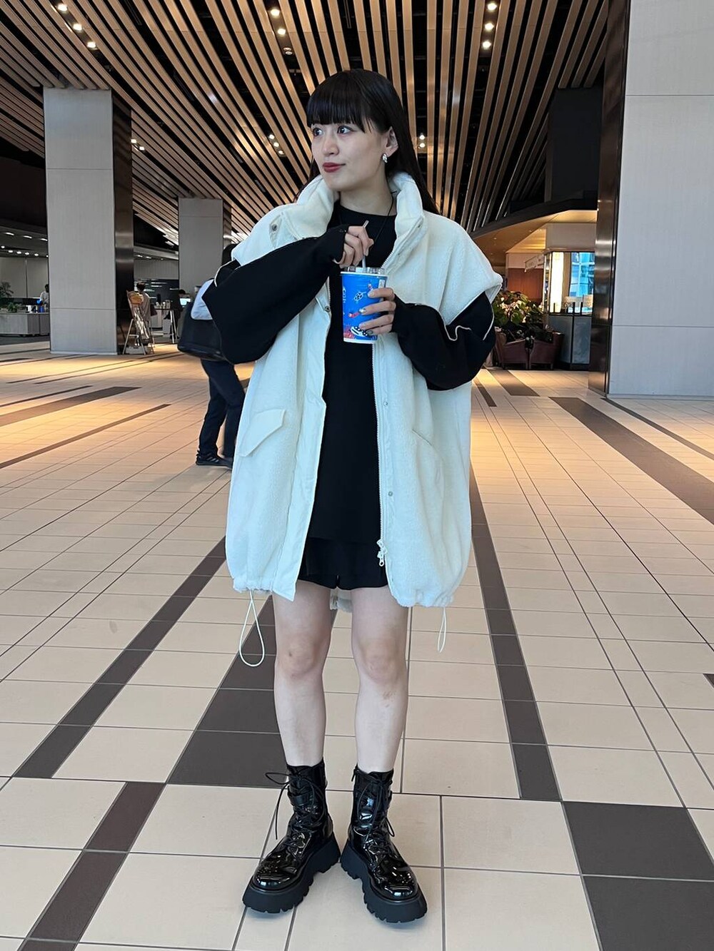 グレー系のハンドバッグ、ブラック系のニット/セーターを着用したレディースの秋コーディネートの2枚目の写真