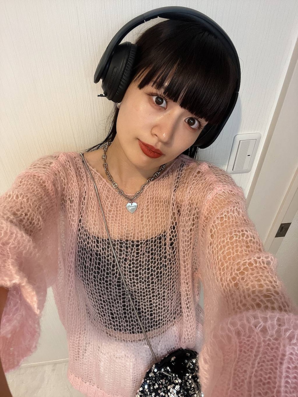 ピンク系のニット/セーター、シルバー系のネックレスを着用したレディースの秋コーディネートの4枚目の写真