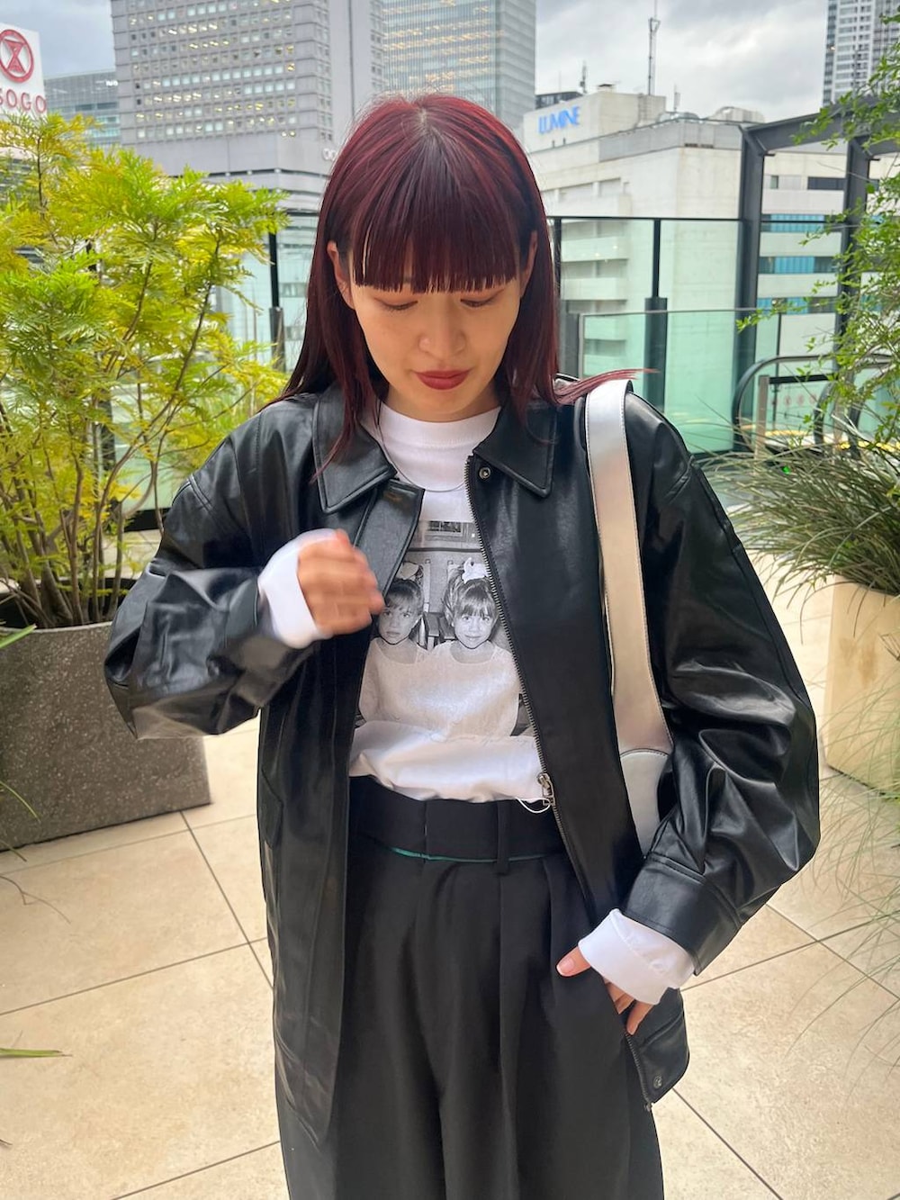 ブラック系のブルゾン、シルバー系のショルダーバッグを着用したレディースの秋コーディネートの2枚目の写真