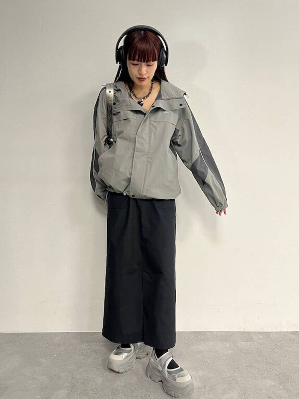 シルバー系のスニーカー、シルバー系のショルダーバッグ、ブラック系のセットアップを着用したレディースの秋コーディネートの4枚目の写真