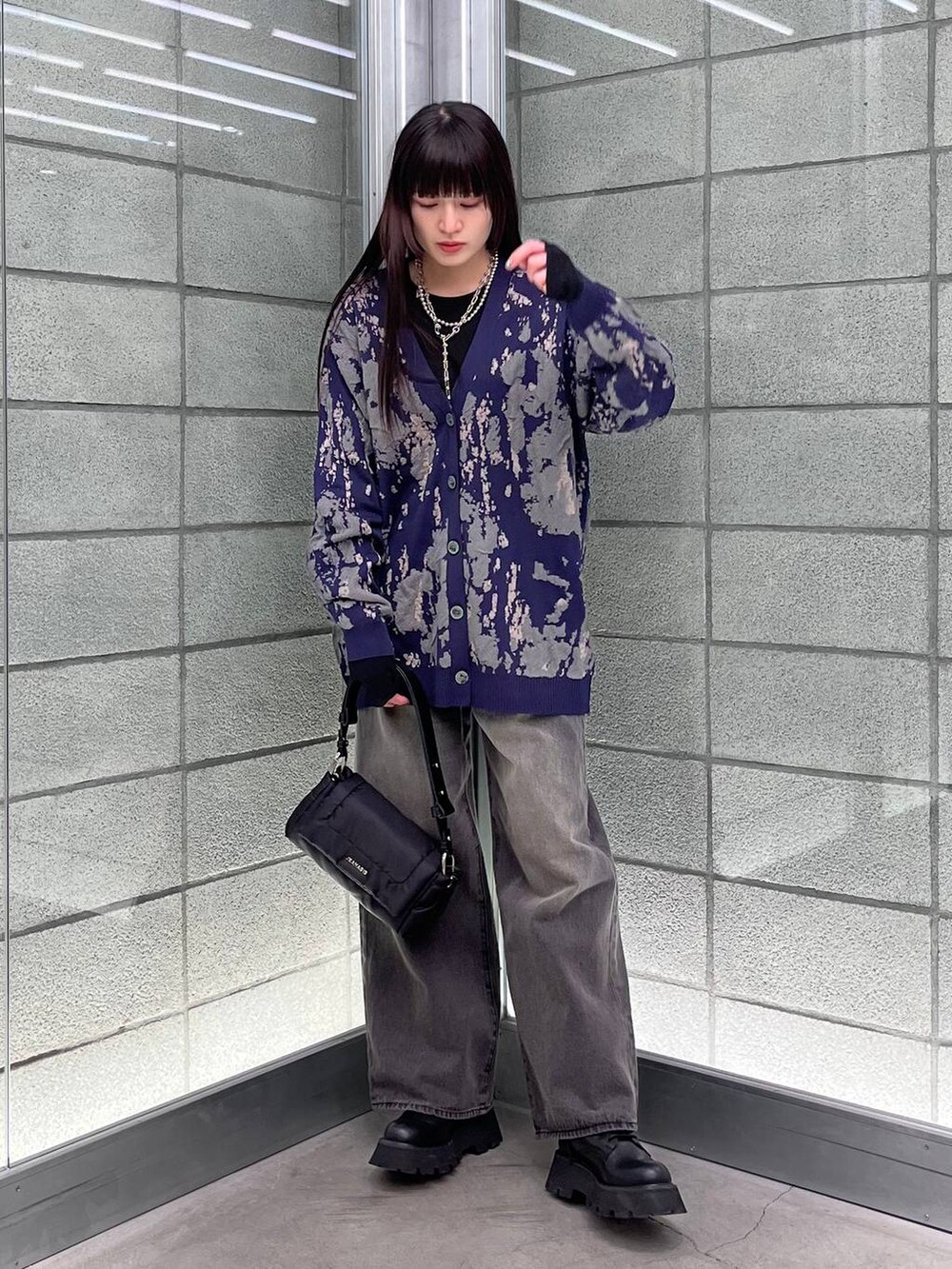 ブルー系のカーディガン/ボレロ、ブラック系のデニムパンツ、ブラック系のショルダーバッグを着用したレディースの冬コーディネートの7枚目の写真