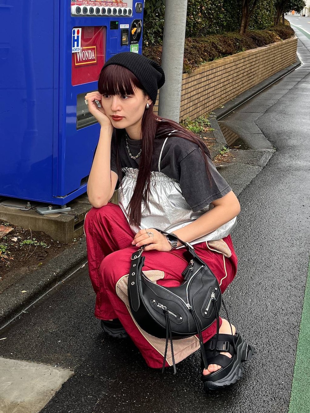 ブラック系のショルダーバッグ、レッド系のその他パンツ、ブラック系のTシャツ/カットソーを着用したレディースの冬コーディネートの3枚目の写真