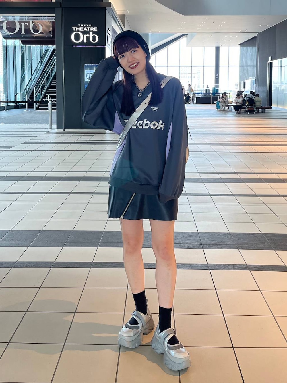 シルバー系のスニーカー、シルバー系のショルダーバッグ、グレー系のスウェットを着用したレディースの秋コーディネートの2枚目の写真