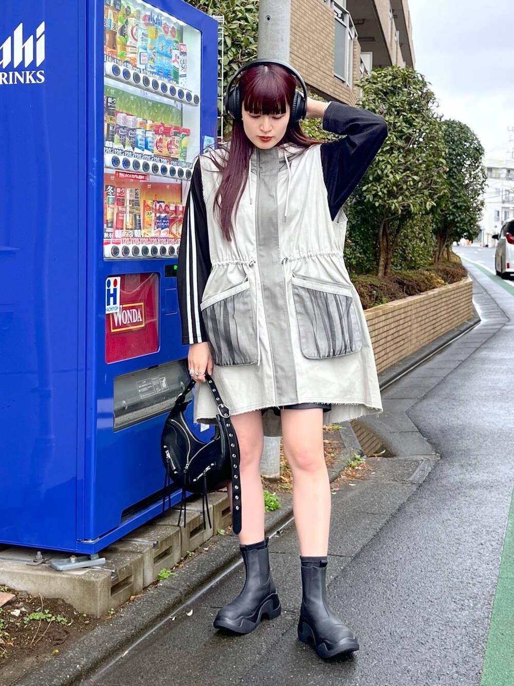 ブラック系のショルダーバッグ、ブラック系のTシャツ/カットソー、ブラック系のブーツを着用したレディースの冬コーディネートの4枚目の写真