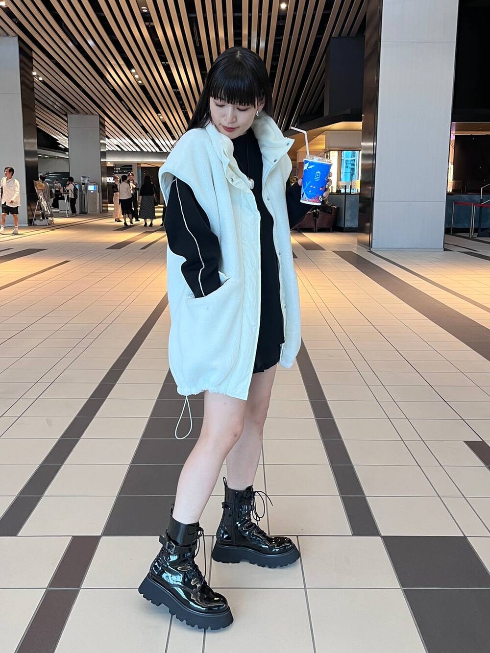 グレー系のハンドバッグ、ブラック系のニット/セーターを着用したレディースの秋コーディネートの4枚目の写真