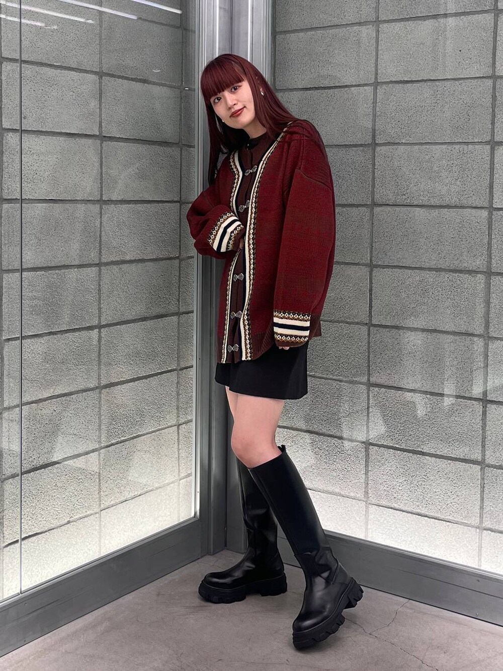 ブラウン系のカーディガン/ボレロ、ブラック系のスカート、ブラック系のブーツを着用したレディースの夏コーディネートの4枚目の写真