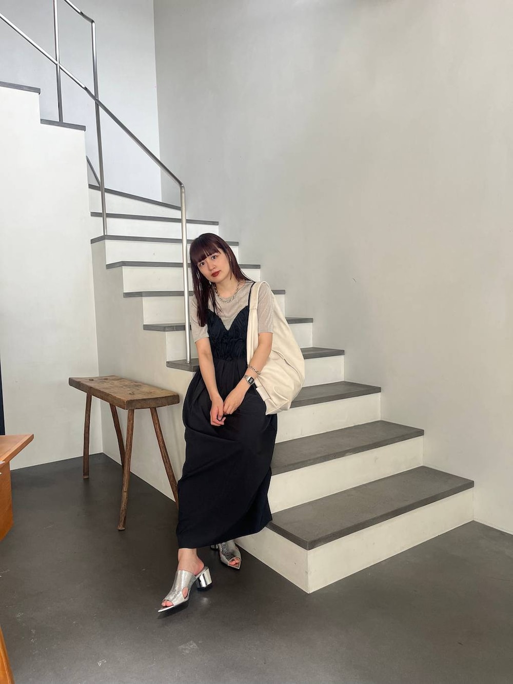 シルバー系のサンダル、シルバー系のTシャツ/カットソー、ブラック系のワンピースを着用したレディースの春コーディネートの3枚目の写真