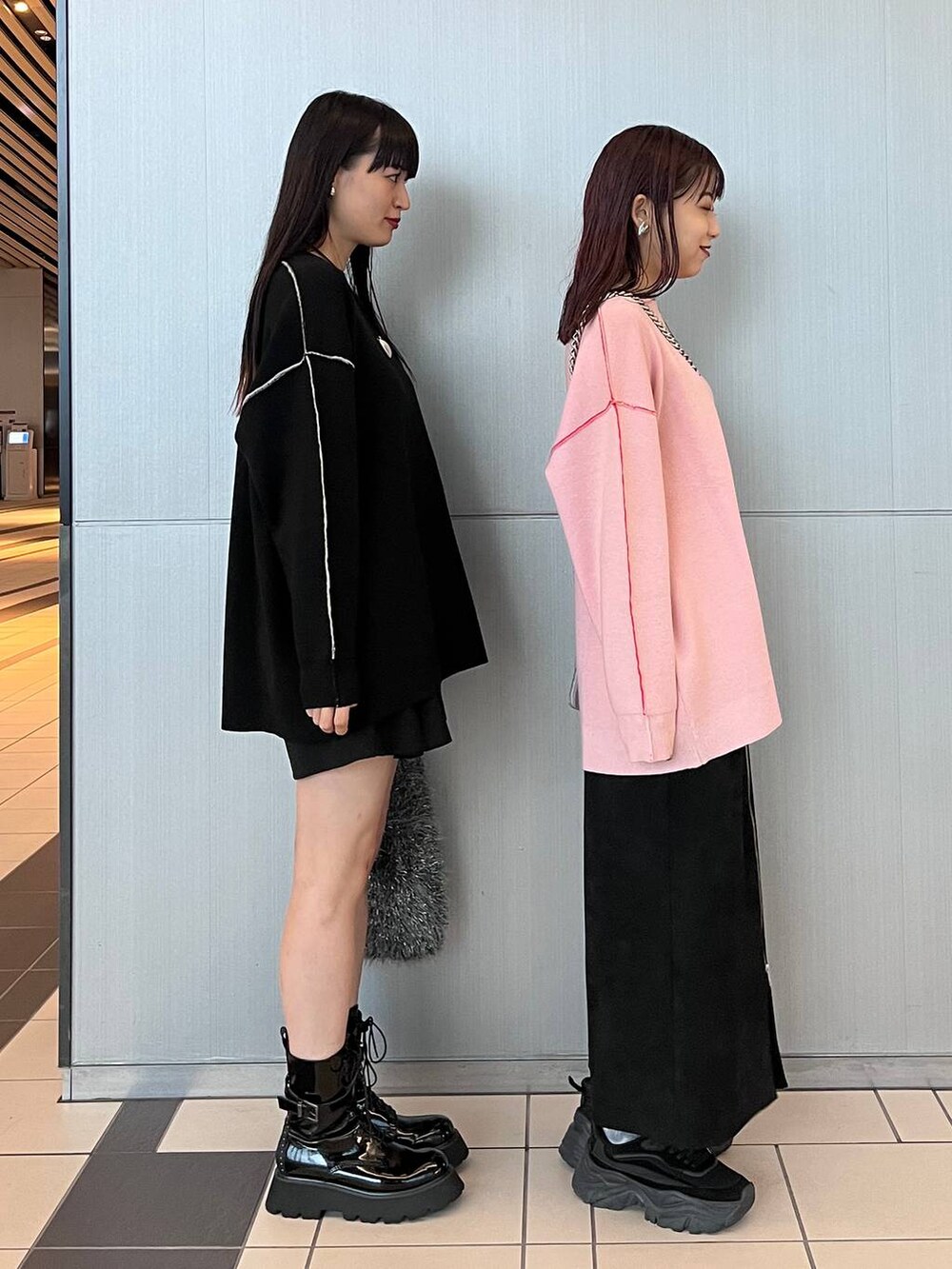 ブラック系のスカート、グレー系のハンドバッグ、ブラック系のブーツを着用したレディースの秋コーディネートの3枚目の写真